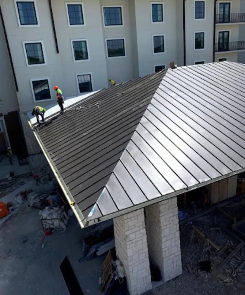 Crew installing standing seam metal roof panels on a commercial project in Fairfax Station